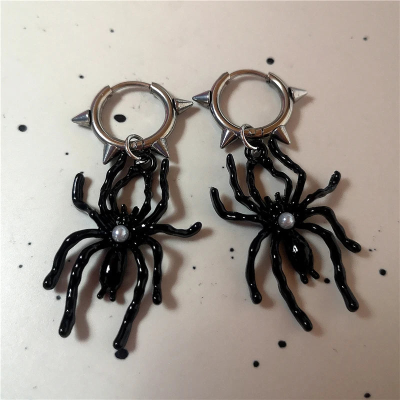 Gothic spider-shaped earrings with intricate web-inspired spirals.